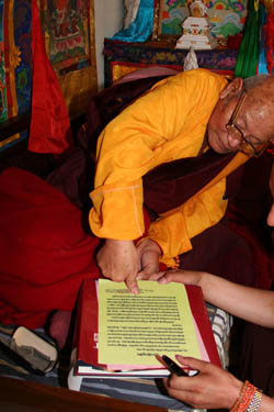 Dorje Rinzin Rinpoche, master of the seventh Dzogchen Dharma King in China, stamps his fingerprint onto the congratulatory letter he wrote to H.H. Dorje Chang Buddha III